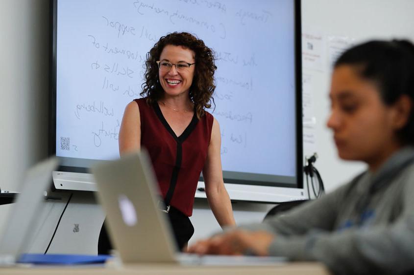 Professor is teaching in a classroom.